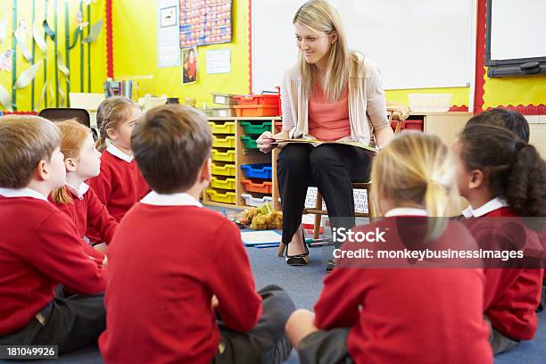 Teacher Reading Story To Elementary School Pupils Stock Photo - Download Image Now - 20-29 Years, 4-5 Years, 6-7 Years