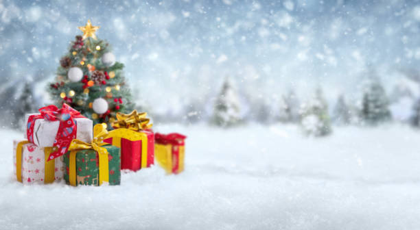 istock Blurred gift boxes and Christmas tree on abstract snow landscape background. 1810500144