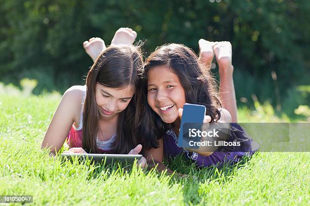 Niñas Jugando Con Reproductor De Mp3 Y Tableta Digital Foto de stock y más banco de imágenes de Acostado