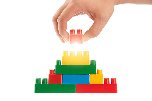 istock Hand building the toy pyramid isolated on white 181051152
