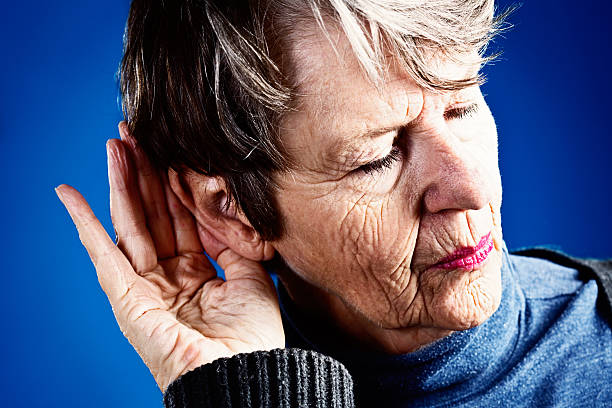 istock What? Deaf old woman cups hand round ear 181052740