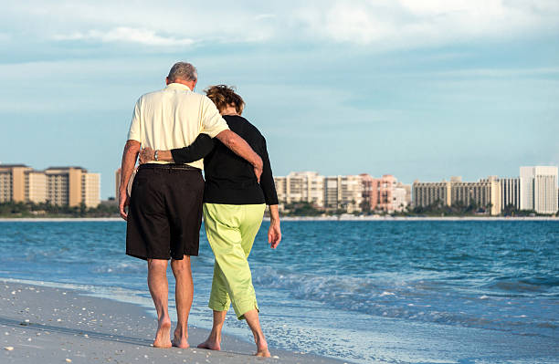 personnes âgées couple marchant sur la plage - shorts rear view summer beach photos et images de collection