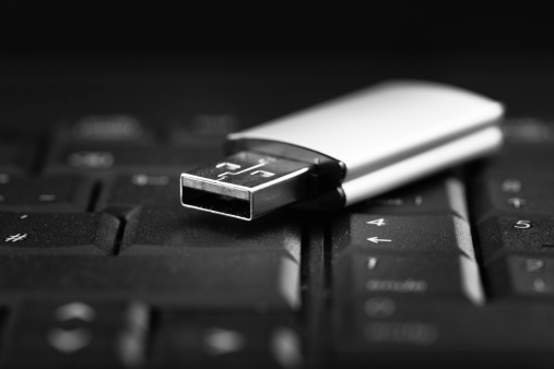 low key shot from an USB stick on a black keyboard, shallow depth of field