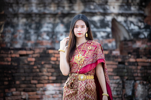 Outdoor image of young beautiful Indian woman wearing traditional Indian dress or Salwar kameez and looking at camera. One person, horizontal composition with selective focus and copy space.