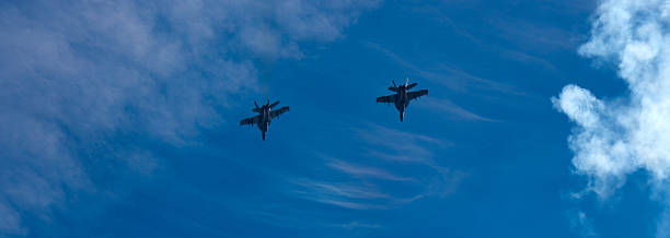 istock Two F-18 Hornet figher jets over a blue sky 181055081