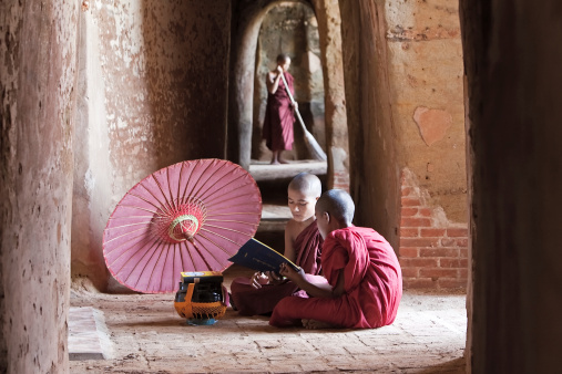Two Buddhist monks reading a book inside the temple