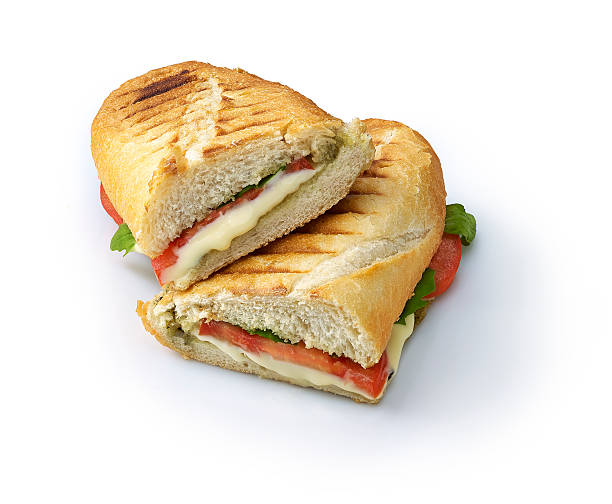 A Sliced in half grilled vegetable panini Grilled panini sandwiches stuffed with basil, roasted tomato and cheese. with clipping path toasted sandwich stock pictures, royalty-free photos & images