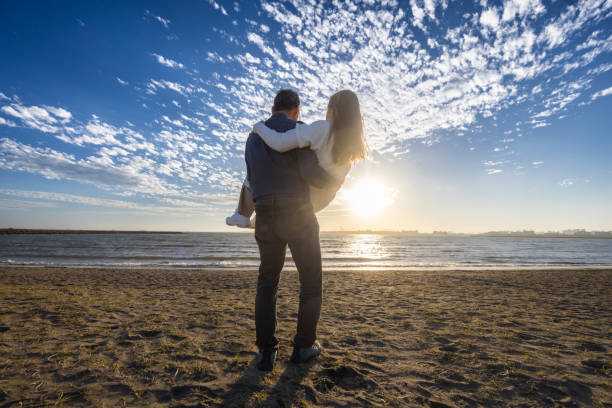 istock Couple on the beach at sunset 1810576438