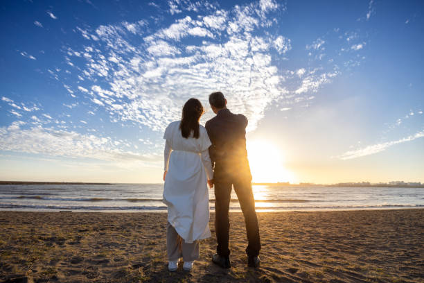 istock Couple on the beach at sunset - standing together 1810576954