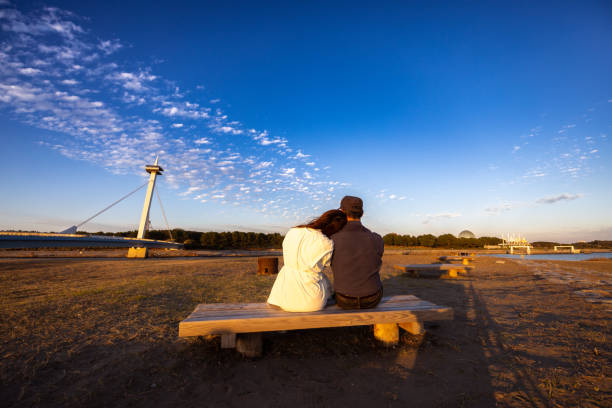 istock Couple sitting on bench at sunset time 1810577501