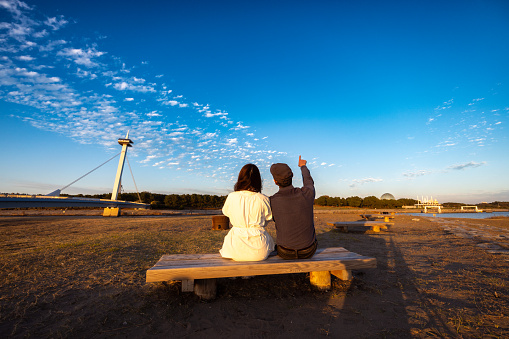 Couple sitting on bench at sunset time