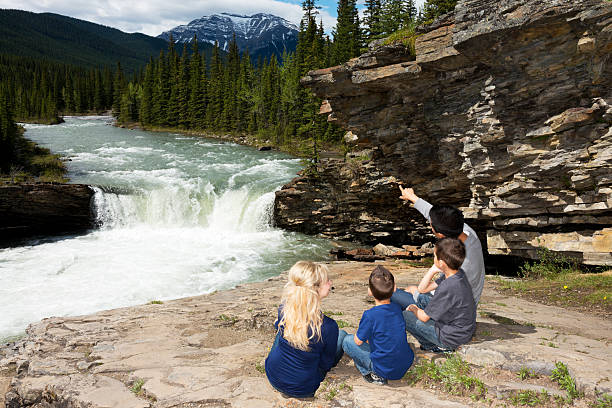 Family in the Mountains A family admiring the view of the Rocky mountains and a waterfall. Kananaskis kananaskis country stock pictures, royalty-free photos & images