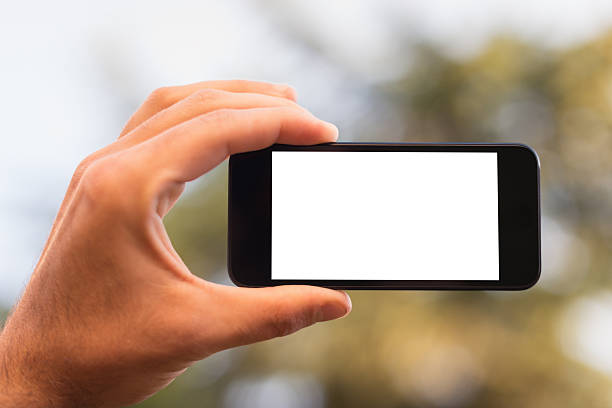 segurando um branco móvel telefone inteligente ao ar livre - smart phone mobile phone palmtop photo messaging - fotografias e filmes do acervo