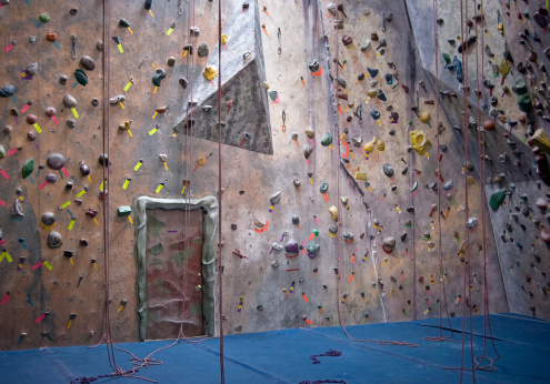Indoor climbing walls with colorful labels and handholds.