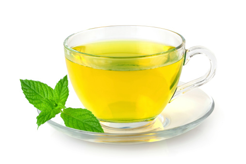 A glass cup of fresh mint tea on white background
