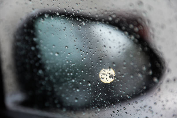 Raindrops adorn windowpane, creating a melancholic ambiance, symbolizing solitude, introspection, and nature's serene beauty on a rainy day