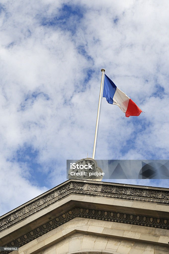 French flag on building in Paris France French flag on building at a cloudy sky in Paris France Building Exterior Stock Photo