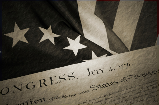 An American Betsy Ross flag close-up and  the Declaration of Independence. Vignetted  Black and white.