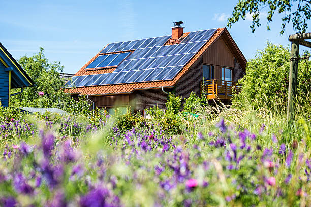 house with solar panels - güneş paneli stok fotoğraflar ve resimler