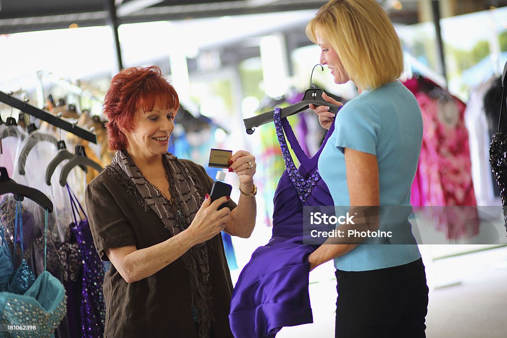 O proprietário de negócios sênior usando cartão de crédito Swiper no telefone celular - Foto de stock de 40-49 anos royalty-free