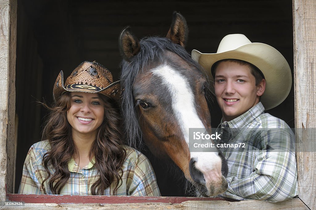 Linda Western casal e cavalo no Barn janela, jovens americanos - Foto de stock de Adolescente royalty-free