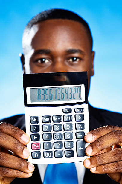 This African-American businessman holds up a calculator, which is showing random figures. You can add whatever numbers or even message you prefer.