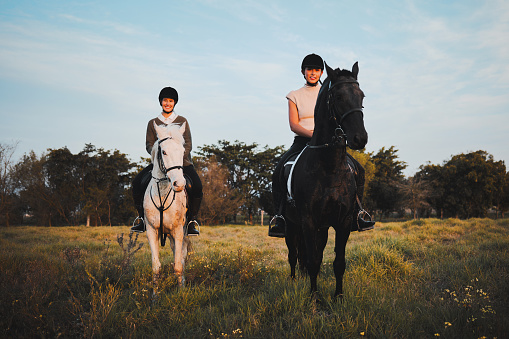Horse ride, friends and countryside with animal, sunset and freedom on holiday and travel. Equestrian, people and field trip with pet in nature on vacation with rider in a meadow or ranch outdoor