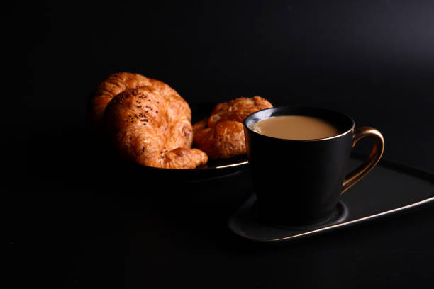istock Hot latte coffee with Croissant coffee break isolated in black background 1810636429