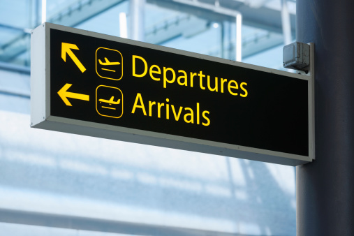 Sign pointing the way to Departures and Arrivals at an airport.