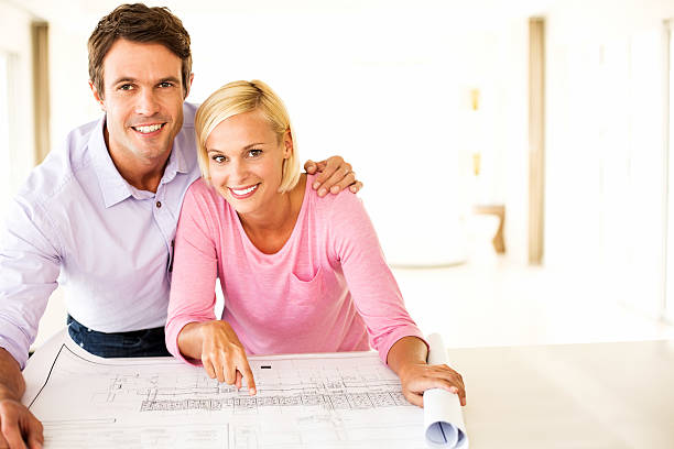 istock Couple With Blueprint Leaning At Table In House 181064117