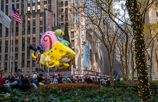 New York, USA - November 23, 2023: SpongeBob SquarePants Balloon floats down at 6th Avenue, at annual Macy's Thanksgiving Day Parade in New York City