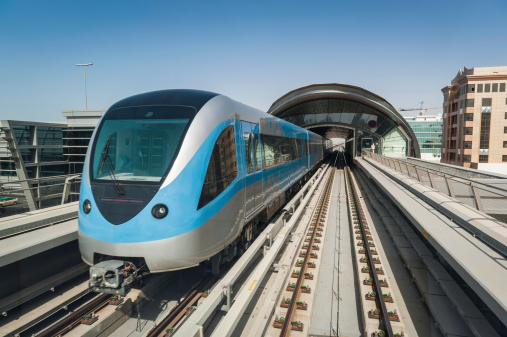 Modern Metro train on Dubai's Rapit Transit rail system below the skyscrapers along Sheikh Zayed Road, UAE. ProPhoto RGB profile for maximum color fidelity and gamut.