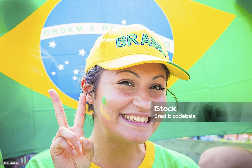 Hermosa mujer ventilador de Brasil equipo de fútbol con la victoria señal - Foto de stock de 20 a 29 años libre de derechos