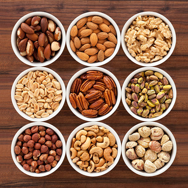 Nuts Nine bowls containing assorted nuts CASHEWS stock pictures, royalty-free photos & images