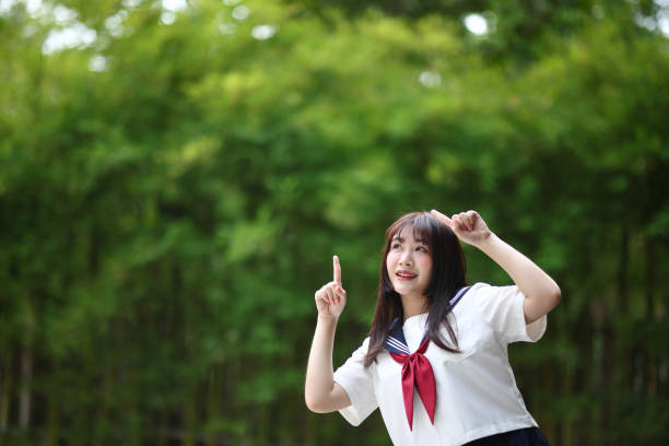 istock Japanese high school student with happy and pointing on copy space in bamboo background 1810662514
