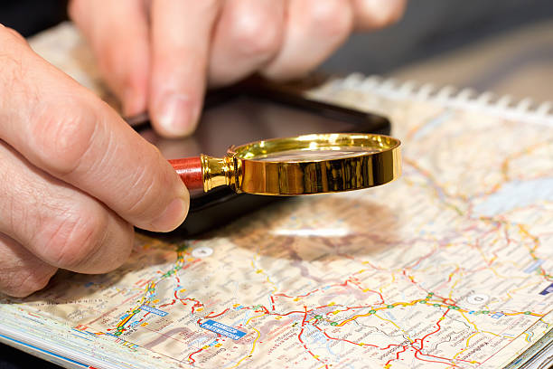 istock male hand with magnifying glass over a map 181066278