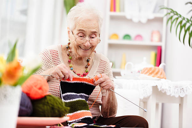 Smiling grandmother knitting Smiling grandmother knitting knitting photos stock pictures, royalty-free photos & images