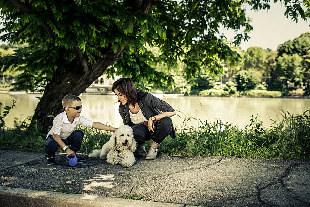 istock Mom and Child Playing with Dog 181066505