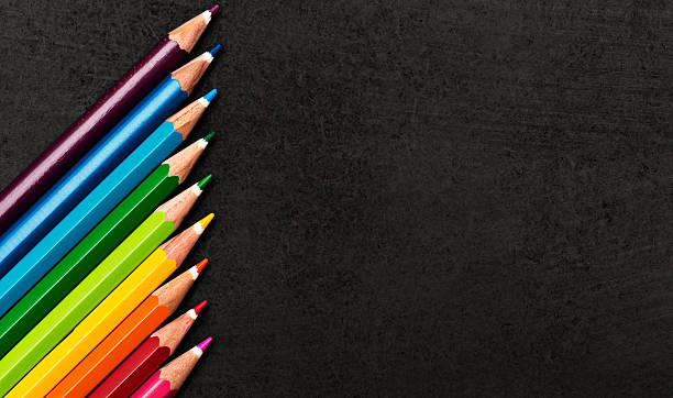 istock Rainbow-colored pencil crayons in diagonal line on black 181066526
