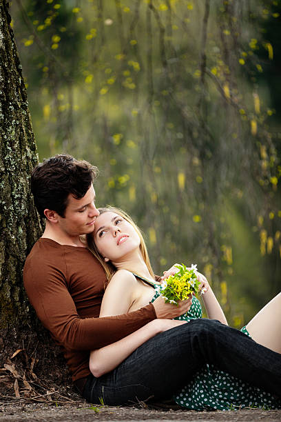 Young Couple Under Tree Stock Photo - Download Image Now - 20-29 Years,  Adult, Adults Only - iStock