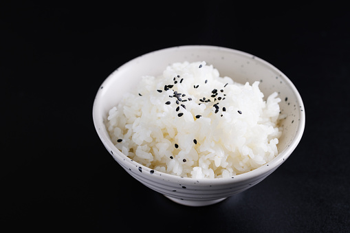 Japanese rice on cup isolated in black background