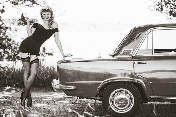 Pin-up girl with car Retro styled black and white photo of a beautiful young woman posing with old Polish (Italian) car in rural scenery. pin up girls and cars stock pictures, royalty-free photos & images