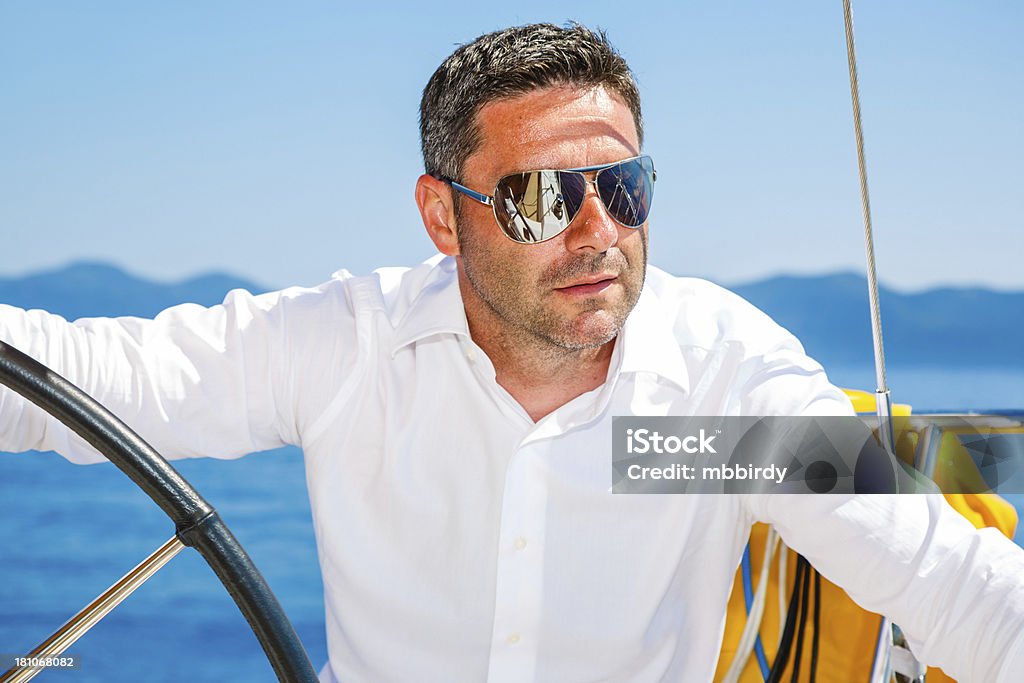 Uomo con barca a vela vela - Foto stock royalty-free di Yacht