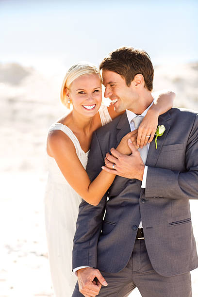 istock Loving Bride Embracing Groom From Behind On Beach 181068687