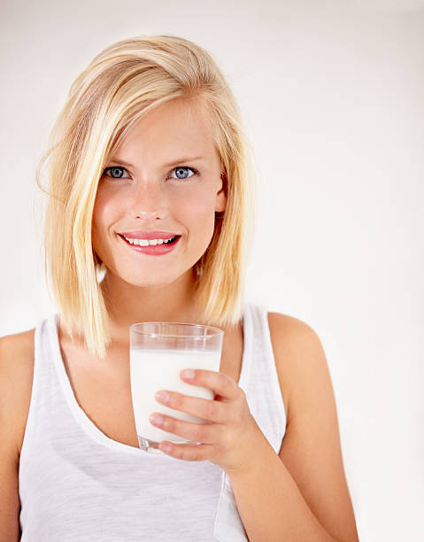 Children eat cookies with milk in glass cups