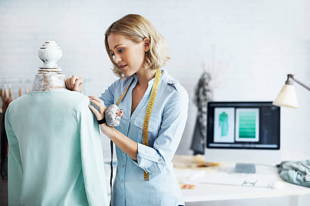 Working hard to reach the top A gorgeous young dressmaker working on her design on a mannequin woman tailor stock pictures, royalty-free photos & images