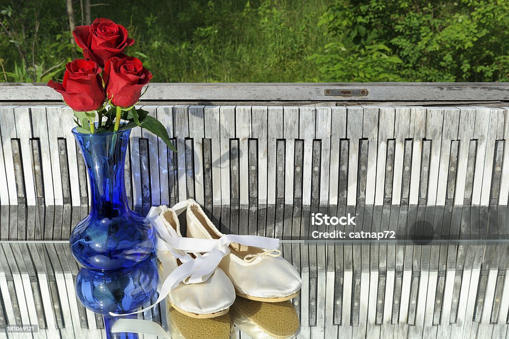 Roses and Ballet Slippers, Piano Keyboard Background, Outdoors "Red roses and ballet slippers with a weathered piano keyboard background, shot outdoors on a mirror." Backgrounds Stock Photo