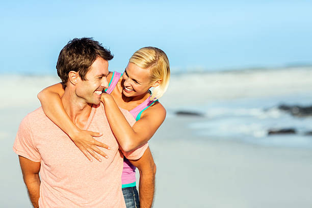 istock Woman Embracing Man From Behind At Beach 181069178