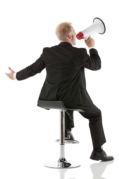 istock Rear view of young man shouting on megaphone 181069673