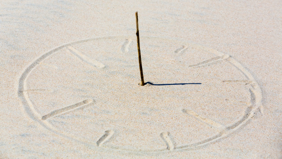 Sun clock in beach sand.
